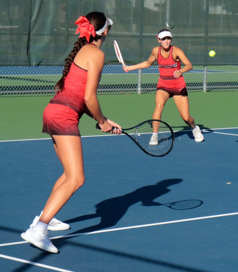 As doubles partner Lydia Bonderer looks on in the foreground, sophomore Lexy Smith of the 2025 Chillicothe High School tennis Lady Hornets swings into a forehand groundstroke during the duoÕs Class 1 District 8 doubles championship match Oct. 10. Previously crowned Midland Empire Conference champs, the Smith-Bonderer tandem added the district doubles title to their resum and followed that up Oct. 23-24 by earning the eighth-place medal in the state tournament at Springfield with two wins in five matches. (PAUL STURM/C-T FILE PHOTO)